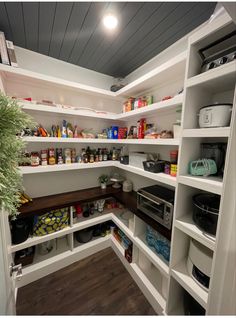 a pantry with white shelving and lots of food on the shelfs in it