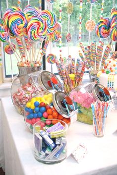 a table topped with lots of candy and lollipops on top of it