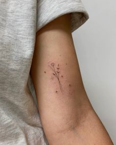 a woman's arm with a flower tattoo on the back of her left arm