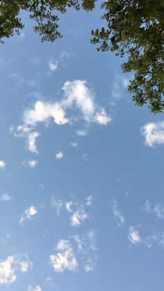 an airplane is flying through the blue sky with some clouds in it's foreground