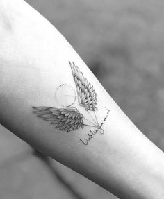 a woman's arm with a tattoo on it that has an angel wing and the word love