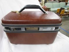 "Store everything in vintage style in Samsonite dark brown textured case complete with fabric lift out pocket and key (NOTE: Stains in interior, surface wear/tear/stains) with top handle, mirrored interior. Case is 9\" height by 14\" length to 7 1/2\" depth. If you choose to arrange to have an item shipped please make sure to insure the shipment as we are not responsible for damage that occurs in shipping. All items are sold \"As Is\" and all sales are final. Most pieces are one of a kind and ca Vintage Brown Briefcase With Top Handle, Vintage Brown Rectangular Case Bag, Vintage Brown Rectangular Luggage, Vintage Samsonite Train Case, Vintage Brown Leather Briefcase, Rectangular, Tear Stains, Butter Molds, Makeup Train Case, Vintage Brush