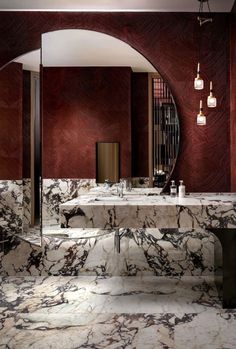 a bathroom with marble counter tops and red walls