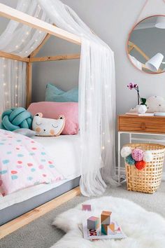 a bedroom with a white canopy bed, pink and blue decor and lights on the ceiling