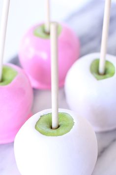 three white and green apples with sticks sticking out of them