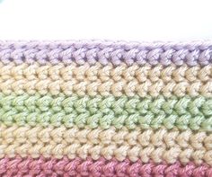 the crocheted blanket is multicolored and has two rows of different colors