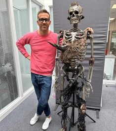 a man standing next to a skeleton statue