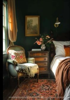 a bed room with a neatly made bed next to a chair and a painting on the wall