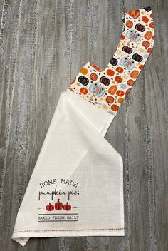 two white kitchen towels with pumpkins on them