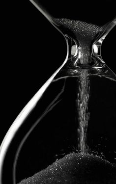 an hourglass with water pouring out of it and the words in arabic above it