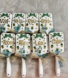 six ceramic spatulas with name tags on them sitting next to each other in a row