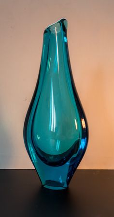 a blue glass vase sitting on top of a table