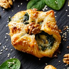 spinach and cheese stuffed pastries on a black surface