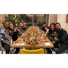 a group of people sitting around a wooden table