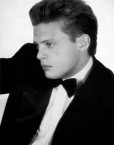 a black and white photo of a man in a tuxedo