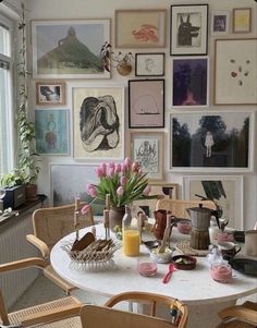 a table with chairs and pictures on the wall