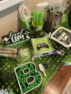 a table topped with lots of candy and other items on top of green trays