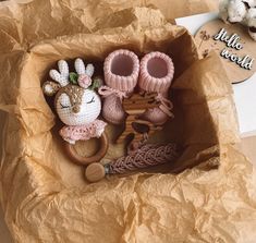 two stuffed animals are sitting in a cardboard box next to some other items on the table