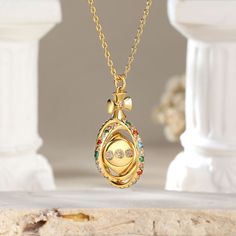 The pendant features a delicate circular frame adorned with an array of vibrant colored stones. At its heart lies a captivating surprise – a dice that gracefully rotates 360°, symbolizing the unpredictability of life's adventures. This unique piece not only reflects your sophisticated taste. Adorn yourself with this exquisite necklace, and let the world witness your flair for both beauty and whimsy.Carat Weight: 0.994 ctStone Size: 1.5,1.6,1.8,2,1.5,1.5 mmNumber of Stones: 73 Stone Color: Garnet Cubic Zirconia Medallion Necklace Gift, Luxury Multicolor Birthstone Jewelry, Gold Multi-stone Round Pendant Jewelry, Luxury Oval Pendant Locket Necklace As Gift, Multicolor Jewelry With Detachable Pendant As Gift, Gold Plated Multi-stone Jewelry Gift, Luxury Round Pendant Locket Necklace As Gift, Gold Plated Multi-stone Jewelry As Gift, Luxury Round Locket Necklace For Gift