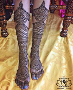 the legs and feet of a woman with henna tattoos