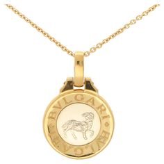 A stylish vintage Buvgari Aries Zodiac pendant in 18k yellow gold and stainless steel. The piece is firstly composed of a circular medallion which is set to the centre with stainless steel panel. Engraved in the stainless steel is a lion, signifying the Leo astrological star sign. The sign is then surrounded by a yellow gold border engraved with the BVLGARI logo. The pendant hangs from a Bvlgari 18ct yellow gold chain. Due to the design and size, this piece could be worn for a variety of occasio Luxury Round Necklaces With Gold-tone Logo Plaque, Yellow Gold Medallion Jewelry With Gold-tone Logo, Yellow Gold Medallion Jewelry With Logo Plaque, Yellow Gold Pendant Jewelry With Gold-tone Logo Plaque, Bvlgari Logo, Stainless Steel Panels, Zodiac Pendant, Gold Border, Aries Zodiac