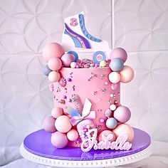 a pink and purple birthday cake sitting on top of a table