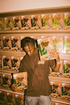 a man holding two packages of cereal in front of shelves