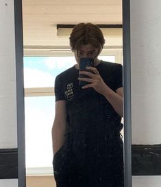 a person standing in front of a mirror holding a cell phone