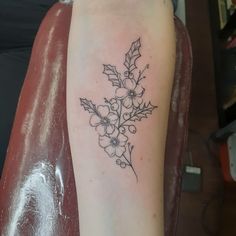 a black and white flower tattoo on the arm