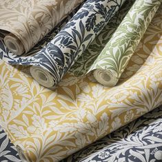 four rolls of fabric in various colors and patterns on a bed sheet or tablecloth