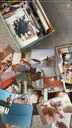 many photographs are spread out on the floor next to an open box with photos in it