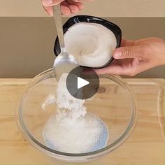 two hands are scooping sugar into a bowl