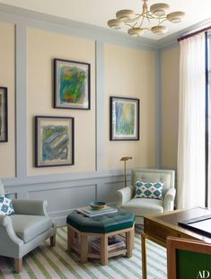 a living room filled with furniture and paintings on the wall