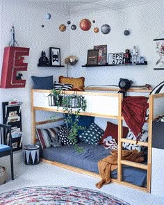 a bunk bed with lots of pillows and decorations on the wall above it in a bedroom