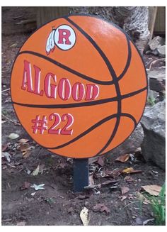 an orange basketball sitting on top of a pile of dirt next to a tree with the words good 122 written on it