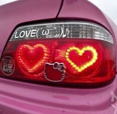 the back end of a pink car with hello kitty stickers on it's tail lights