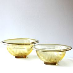 two yellow glass bowls sitting next to each other