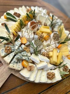 a platter with cheeses and nuts on it