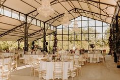 an indoor venue with tables and chairs set up for a formal function in front of large windows