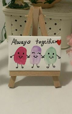 a small easel holding a sign that says,'always together'with three little cartoon characters painted on it