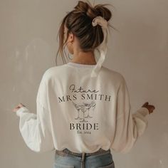 a woman wearing a white sweatshirt with the words mrs smith and bride printed on it