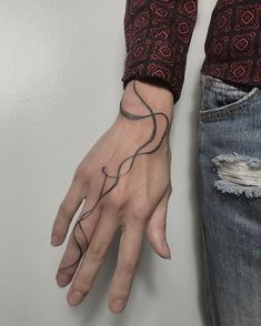 a person's hand with a tattoo on it and a ring around the wrist