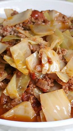 a white bowl filled with cabbage and meat