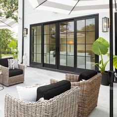 an outdoor living room with wicker furniture