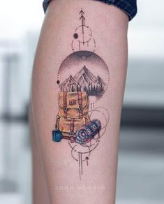 a person with a tattoo on their leg that has a backpack and compass on it