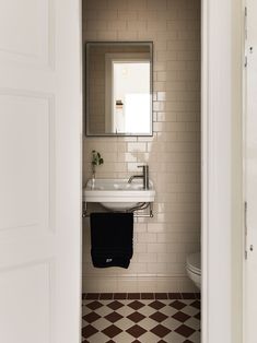 an open door leading to a bathroom with a sink and mirror on the wall next to a toilet