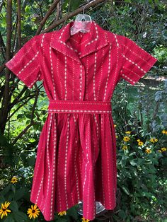 1940s girls red cotton daisy stripe dress: This little red print dress appears to be a 6-8. It is in a lovely shade of red with little white and gold daisy stripes. It is collared and has a natural waistline. The skirt is gathered. The back has a western cut. It buttons front center with red buttons. It has a sash lined in gold Measurements: Shoulder to shoulder 13 in. Chest 30 in. Waist23 in. Length 29 in. Red Vintage Short Sleeve Dress For Spring, Red Short Sleeve Vintage Dress For Spring, Red 1950s Style Spring Dress, Vintage Red Short Sleeve Dress, Red Cotton Vintage Summer Dress, 1950s Red Lined Dress, 1950s Style Red Lined Dress, Red 1950s Spring Dresses, Red Cotton Vintage Dress