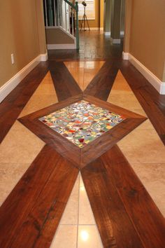 the floor is made out of wood and has many different colored glass tiles on it