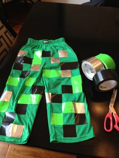 a pair of green shorts sitting on top of a table next to a roll of tape