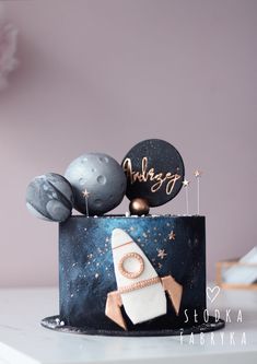 a space themed birthday cake with balloons on top